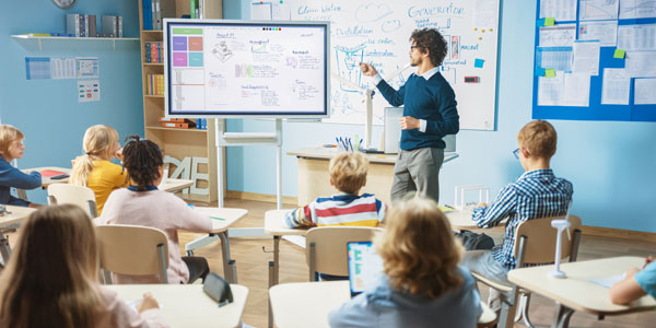 A teacher using an interactive screen as a whiteboard